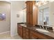 Bathroom featuring double sinks with granite countertops and wooden cabinetry at 1625 Lancashire Dr, Venice, FL 34293