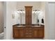 Bathroom featuring double sinks with granite countertops and wooden cabinetry at 1625 Lancashire Dr, Venice, FL 34293