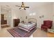 Charming bedroom featuring a gold bed frame, ceiling fan and a large area rug at 1625 Lancashire Dr, Venice, FL 34293