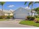 Charming light blue single-Gathering home with a paved driveway and a two-car garage, surrounded by lush landscaping at 1625 Lancashire Dr, Venice, FL 34293