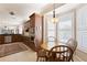 Sunlit breakfast nook with wood table and cabinets off an open kitchen at 1625 Lancashire Dr, Venice, FL 34293