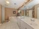 Bathroom with tiled floors, a soaking tub, double sinks and a window to let in natural light at 1653 Albino St, Nokomis, FL 34275