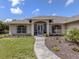 Attractive home entrance with a tiled walkway, screen door, and colorful landscaping at 1653 Albino St, Nokomis, FL 34275