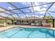 Beautiful pool area featuring an outdoor kitchen, dining, and lounge area, all within a screened enclosure at 1653 Albino St, Nokomis, FL 34275
