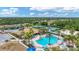 Aerial view showcasing community pool, clubhouse, tennis courts, playground, tiki bar, and lush landscaping at 2094 Mesic Hammock Way, Venice, FL 34292
