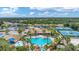 Aerial view showcasing community pool, clubhouse, tennis courts, playground, and lush landscaping with pond at 2094 Mesic Hammock Way, Venice, FL 34292