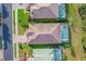 Aerial view showcases tiled roofs, lush landscaping, and screened-in pools of neighboring homes at 2094 Mesic Hammock Way, Venice, FL 34292