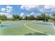 Outdoor basketball court with multiple hoops, benches, and a swing set in the background at 2094 Mesic Hammock Way, Venice, FL 34292