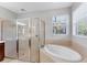 Bathroom with a glass shower, large tub and window with natural light at 2094 Mesic Hammock Way, Venice, FL 34292