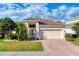 Charming single-story home with a well-manicured lawn, lush landscaping, and a brick-paved driveway at 2094 Mesic Hammock Way, Venice, FL 34292