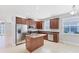 Well-lit kitchen featuring dark wood cabinets, stainless steel appliances, and a functional center island at 2094 Mesic Hammock Way, Venice, FL 34292