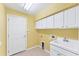 Bright laundry room with cabinets, sink, and tile flooring at 2094 Mesic Hammock Way, Venice, FL 34292