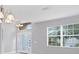 Open living room with high ceiling, tile flooring, large windows, and decorative lighting at 2094 Mesic Hammock Way, Venice, FL 34292