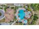 Aerial view of a resort-style pool with lush landscaping, umbrellas, and comfortable lounge chairs at 2094 Mesic Hammock Way, Venice, FL 34292