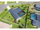 Aerial view of a private home with a screened pool, lush landscaping, and fenced yard in a quiet neighborhood at 23 Tiffany St, Englewood, FL 34223
