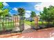 Backyard garden entrance with decorative urns, black wrought iron gate, and lush green lawn at 23 Tiffany St, Englewood, FL 34223