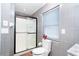 Modern bathroom with gray tiling, a glass-enclosed shower, and updated fixtures at 23 Tiffany St, Englewood, FL 34223