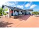 Stylish home showcasing a patterned privacy wall, mature landscaping, and a bright red driveway at 23 Tiffany St, Englewood, FL 34223
