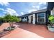 Stylish home featuring an outdoor lounge area, mature landscaping, and a bright red driveway at 23 Tiffany St, Englewood, FL 34223