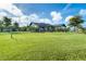 Well-manicured front yard with lush lawn and decorative fence, leading to a welcoming single-story home at 23 Tiffany St, Englewood, FL 34223
