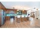 Modern kitchen featuring wood cabinets, stainless steel appliances, and a breakfast bar with stylish pendant lighting at 23 Tiffany St, Englewood, FL 34223