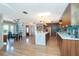 Spacious, open kitchen with light wood floors, stainless steel appliances, and a large island with seating at 23 Tiffany St, Englewood, FL 34223