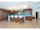 Bright kitchen featuring wooden cabinets, a breakfast bar with white modern stools, and stainless steel appliances at 23 Tiffany St, Englewood, FL 34223