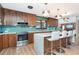 Well-lit kitchen showcasing wood cabinets, a center island with bar seating, stainless steel appliances, and tile backsplash at 23 Tiffany St, Englewood, FL 34223