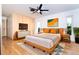 Bright main bedroom with wood floors, ceiling fan, and modern decor at 23 Tiffany St, Englewood, FL 34223