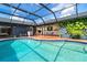 This backyard boasts a screened-in pool and a brick paver patio at 23 Tiffany St, Englewood, FL 34223