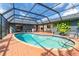 Beautiful pool and patio area featuring an in-ground pool, screened enclosure, and tasteful landscaping at 23 Tiffany St, Englewood, FL 34223