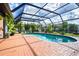 Sparkling in-ground pool surrounded by brick patio and lush landscaping, creating a relaxing outdoor oasis at 23 Tiffany St, Englewood, FL 34223