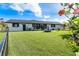 Spacious backyard with well-maintained lawn, black fencing, and flowering hibiscus tree at 23 Tiffany St, Englewood, FL 34223