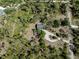 Aerial view of a wooded home site with mature trees, circular driveway and garden at 2450 Flagami Ln, North Port, FL 34286