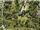 Aerial view of a home surrounded by trees with a circular driveway at 2450 Flagami Ln, North Port, FL 34286