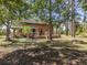 Scenic backyard showcasing a well-kept lawn, a wooden deck and patio, and mature trees at 2450 Flagami Ln, North Port, FL 34286