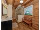 Bathroom features wood walls, shower with glass door, and a wood bench at 2450 Flagami Ln, North Port, FL 34286