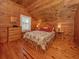 Charming bedroom with knotty pine walls, wood floors, and a floral-patterned bed at 2450 Flagami Ln, North Port, FL 34286