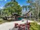 Charming log home with green accents, a gravel driveway, and lush landscaping at 2450 Flagami Ln, North Port, FL 34286