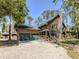 Attractive log home featuring a stone chimney and a convenient two-car garage at 2450 Flagami Ln, North Port, FL 34286