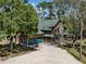 Charming log home exterior with an attached garage, porch, and long gravel driveway at 2450 Flagami Ln, North Port, FL 34286