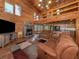 Comfortable living room in a log home with a stone fireplace and vaulted ceilings at 2450 Flagami Ln, North Port, FL 34286