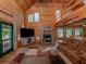 Spacious log home living room features a stone fireplace and open floor plan at 2450 Flagami Ln, North Port, FL 34286