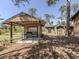 Exterior view of outbuildings with covered area and grill surrounded by natural landscape at 2450 Flagami Ln, North Port, FL 34286