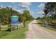 Inviting entrance to Deer Prairie Creek Preserve, showcasing a scenic gravel road and lush natural surroundings at 2450 Flagami Ln, North Port, FL 34286