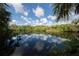 Tranquil waterfront view reflecting the clear blue sky, showcasing a serene and natural environment at 2450 Flagami Ln, North Port, FL 34286