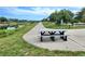 Scenic paved path with a gray picnic table nestled beside a tranquil canal and lush greenery at 250 Santa Maria St # 216, Venice, FL 34285