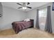 This cozy bedroom features neutral-toned walls, carpet, ceiling fan, and a window with grey curtains at 4068 Palau Dr, Sarasota, FL 34241