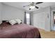 This neutral bedroom features a ceiling fan, white closet doors, and a window with grey curtains at 4068 Palau Dr, Sarasota, FL 34241