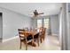 Bright dining room with large table, ceiling fan, natural light, neutral walls, and tile floors at 4068 Palau Dr, Sarasota, FL 34241